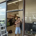 Technician refinishing the storefront frame after the glass went in