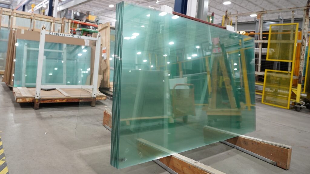 Safety & Bullet-Resistant Glass sheets stacked in a warehouse, ready for installation. Glass provides security and protection | American Glass and Door