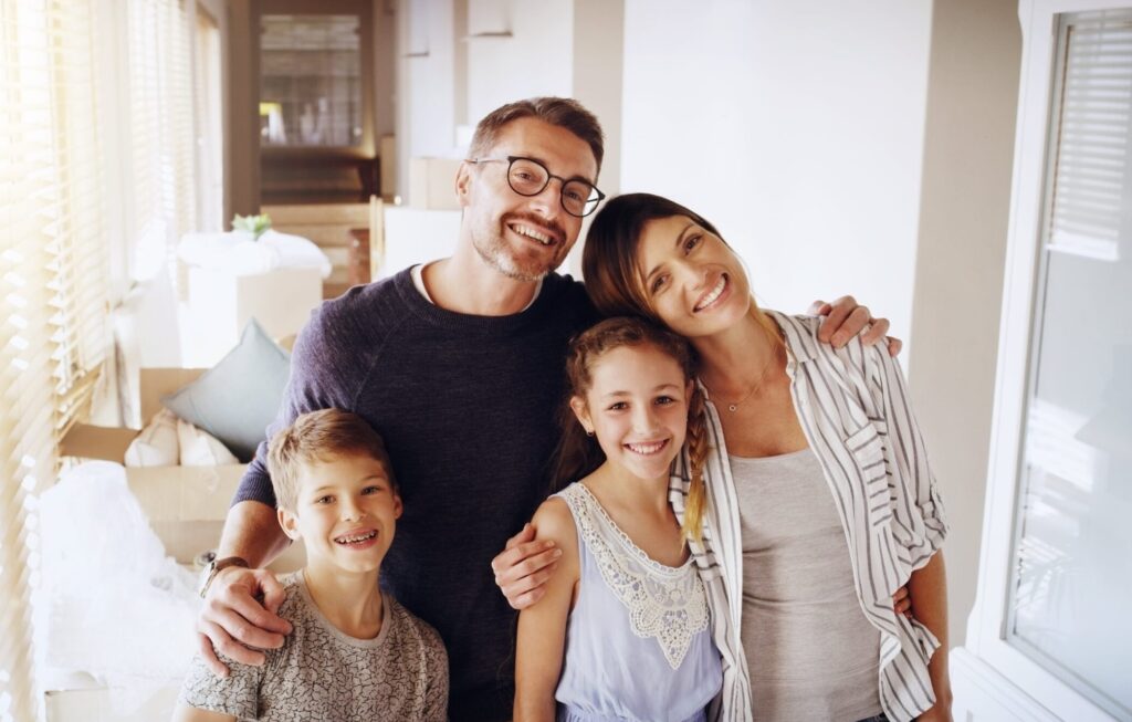 Happy family with moving boxes. Consider a Custom Mirror to enhance your new home's aesthetic and functionality. Custom Mirror Install | American Glass and Door