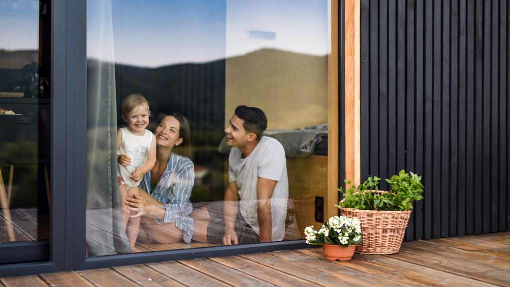Maryland family looks out a sliding glass door, enjoying their home. High-quality glass doors improve a home's value and curb appeal | American Glass and Door