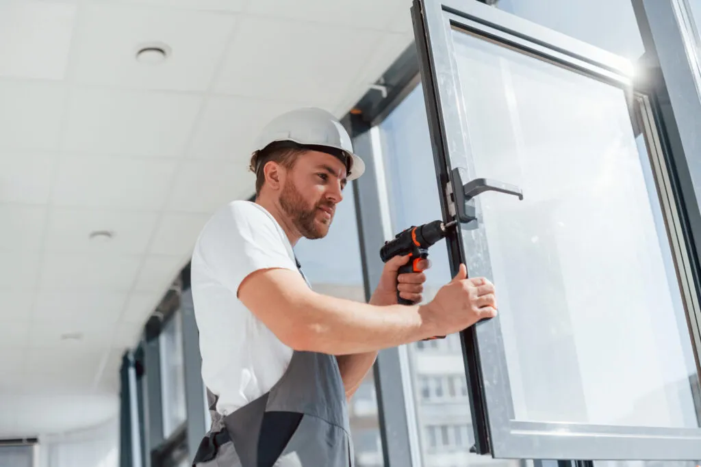A tradesperson fitting and adjusting a commercial door frame